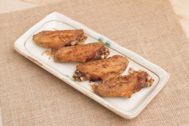 Kızarmış tavuk kanatları ve plaka gevrek sarımsak