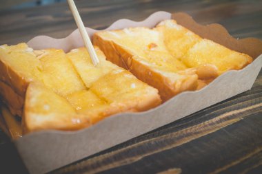 Ahşap masa üzerinde şekerli yoğunlaştırılmış süt ile tost ekmeği.