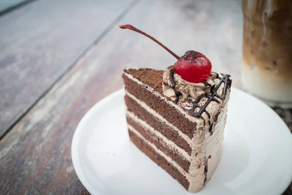 chocolate cake with cherry topping in cozy outdoor cafe