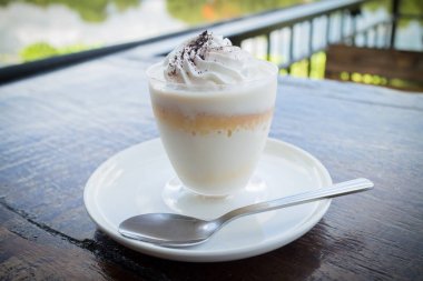 Ahşap masa peçeteye üzerine rendelenmiş çikolata ile lezzetli süt puding