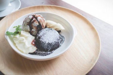 vanilyalı dondurma topu, muz ve krem şanti ile sıcak çikolata lav kek (vintage etkisi)