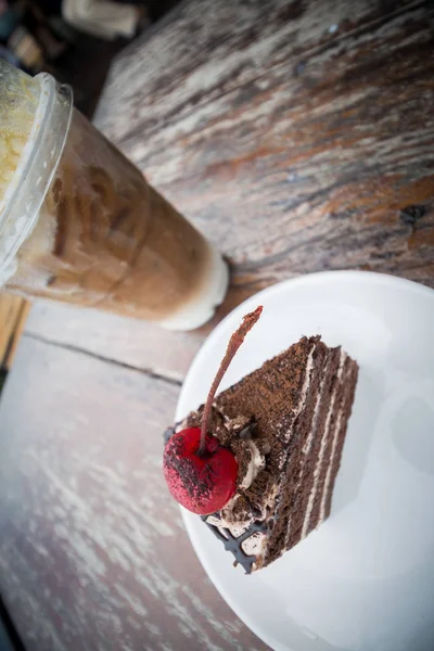 chocolate cake with cherry topping and ice coffee mocha in outdoor cafe
