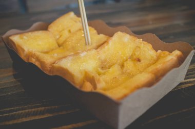 Ahşap masa üzerinde şekerli yoğunlaştırılmış süt ile tost ekmeği.