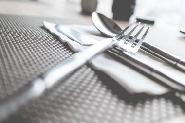 Tahta bir masanın üzerinde tabaklar ve çatal bıçak takımı. Çatal çatal çatal seti, kaşık ve bıçak vintage tema