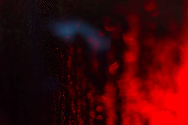 Streszczenie rozmycie tła czerwonego oświetlenia podczas deszczu — Zdjęcie stockowe