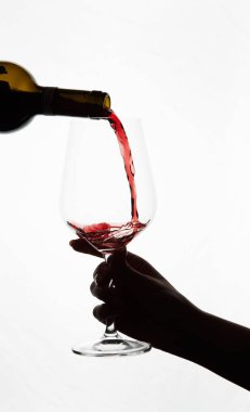 Kırmızı şarap bardağa dökülür.