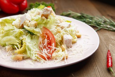 Sezar salatası bir ahşap zemin üzerine bir tabak içinde