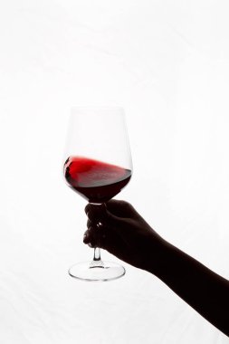 Bir kadeh kırmızı şarap tutan el.