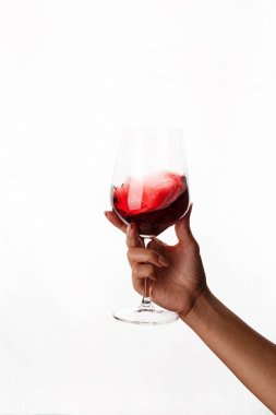 Bir kadeh kırmızı şarap tutan el.
