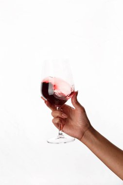 Bir kadeh kırmızı şarap tutan el.