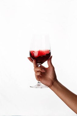 Bir kadeh kırmızı şarap tutan el.