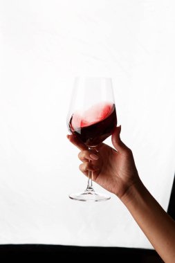 Bir kadeh kırmızı şarap tutan el.