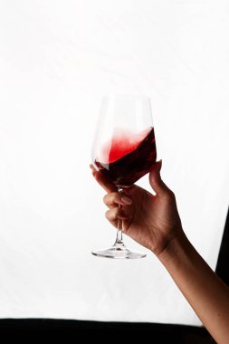 Bir kadeh kırmızı şarap tutan el.