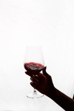 Bir kadeh kırmızı şarap tutan el.