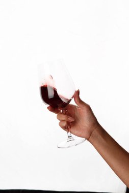 Bir kadeh kırmızı şarap tutan el.