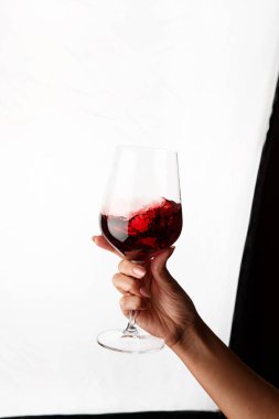Bir kadeh kırmızı şarap tutan el.