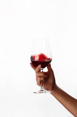 Bir kadeh kırmızı şarap tutan el.