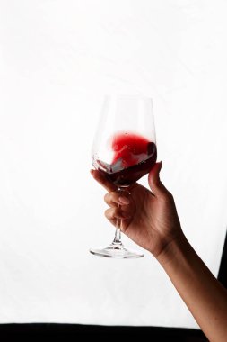 Bir kadeh kırmızı şarap tutan el.