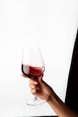 Bir kadeh kırmızı şarap tutan el.