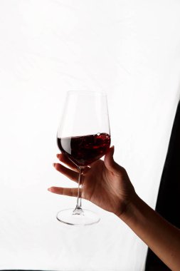 Bir kadeh kırmızı şarap tutan el.