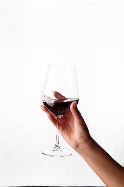 Bir kadeh kırmızı şarap tutan el.