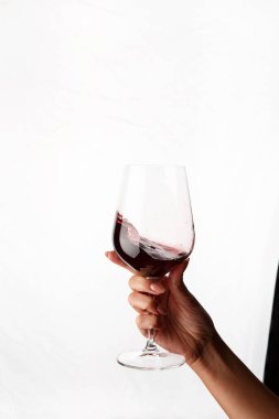 Bir kadeh kırmızı şarap tutan el.