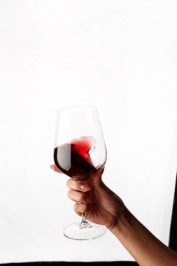 Bir kadeh kırmızı şarap tutan el.