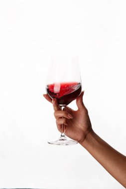 Bir kadeh kırmızı şarap tutan el.