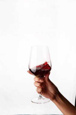 Bir kadeh kırmızı şarap tutan el.
