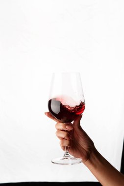 Bir kadeh kırmızı şarap tutan el.