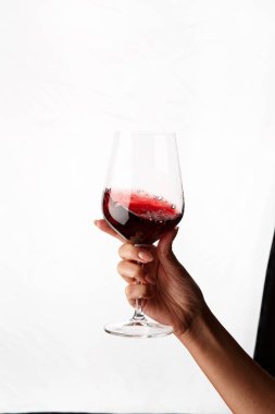 Bir kadeh kırmızı şarap tutan el.