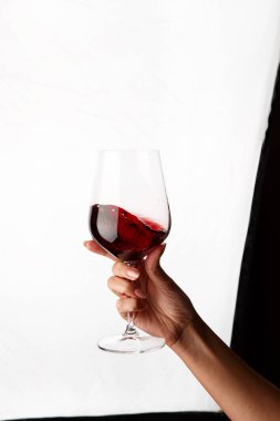 Bir kadeh kırmızı şarap tutan el.