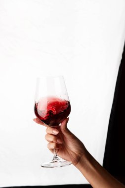 Bir kadeh kırmızı şarap tutan el.