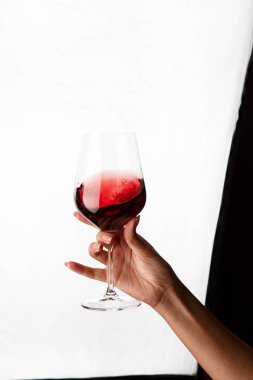 Bir kadeh kırmızı şarap tutan el.