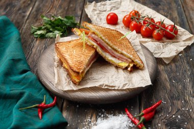 Panini yığını bir kesme tahtası üzerinde jambon, peynir ve salata sandviç ile