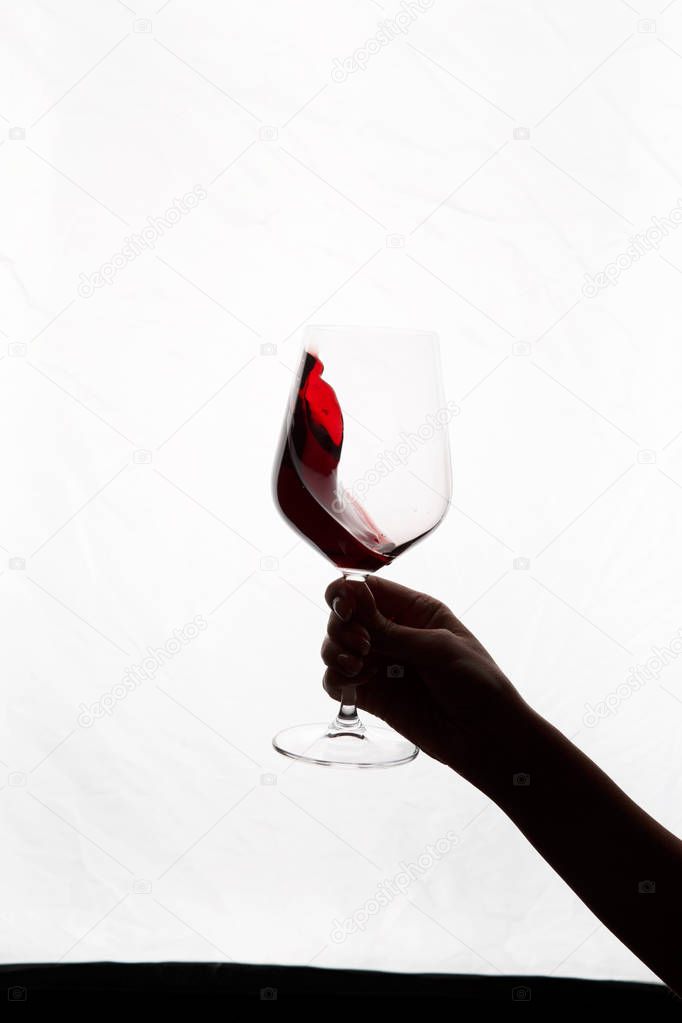 hand holding a glass of red wine