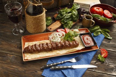Geleneksel Türk ve Arap Kebap plaka üzerinde ahşap masa. Kebap masayı salata, meze ve soslar ile