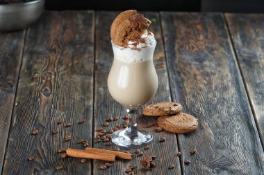 ahşap bir masa üzerinde kurabiye ile kahve latte