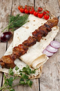 ahşap bir masada çeşitli barbekü şişler