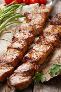 ahşap bir masa üzerinde domuz şiş, seçici odak