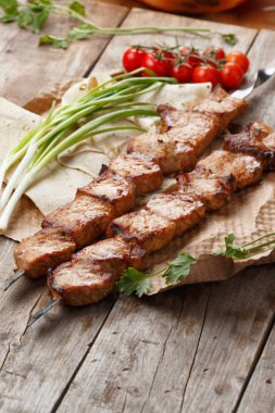 ahşap bir masa üzerinde domuz şiş, seçici odak