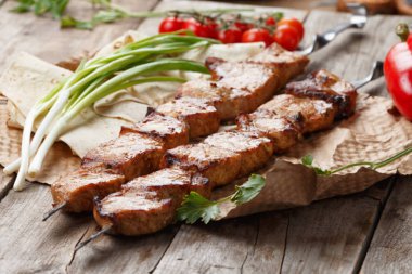 ahşap bir masa üzerinde domuz şiş, seçici odak