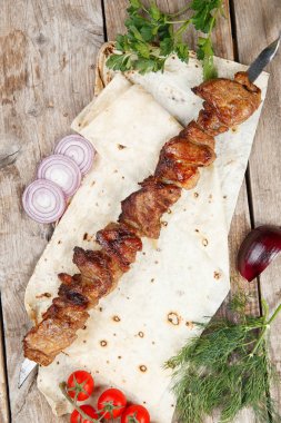 ahşap bir masada çeşitli barbekü şişler