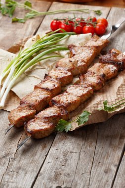 ahşap bir masa üzerinde domuz şiş, seçici odak