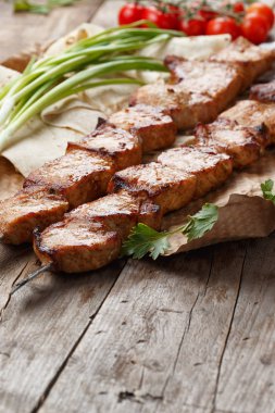 ahşap bir masa üzerinde domuz şiş, seçici odak