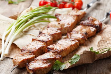 ahşap bir masa üzerinde domuz şiş, seçici odak