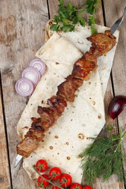 ahşap bir masada çeşitli barbekü şişler