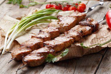 ahşap bir masa üzerinde domuz şiş, seçici odak