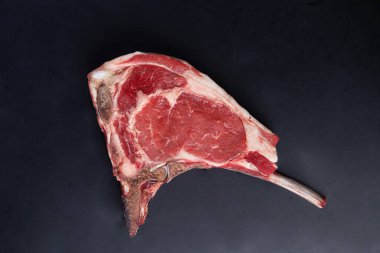 Siyah arka planda klasik çiğ kemik bifteği. Yakın plan.
