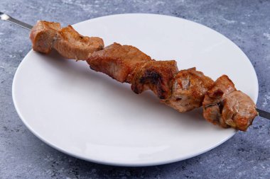 Gri arka planda bir tabakta kebap. yakın plan